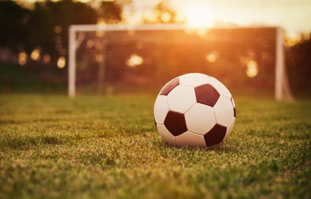soccer-ball-on-field-near-against-setting-sun