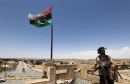 A rebel fighter looks out from the roof of a house in the city of Kikla