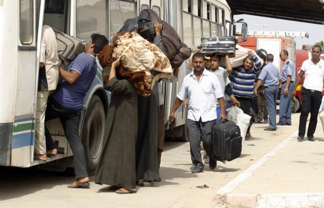 Egyptian men,   who had crossed the border into Tunisia from Libya,   board buses to be transported to Egypt,   at the Ras Jdir border crossing