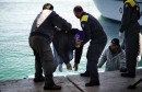 Italian coast guards help an immigrant o