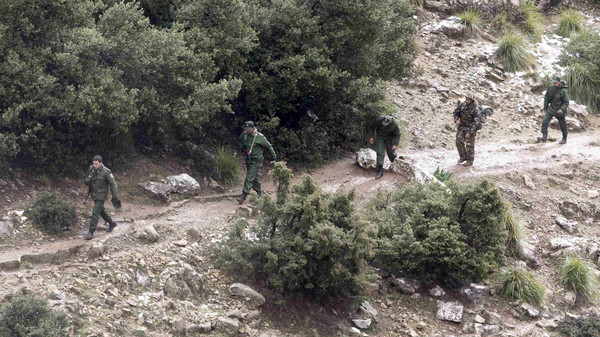 Soldiers arrive at the site of a military plane crash near the village of Ouled Gacem in eastern Algeria