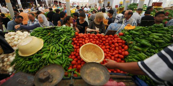 Tunisian shoppers browse vegetables disp