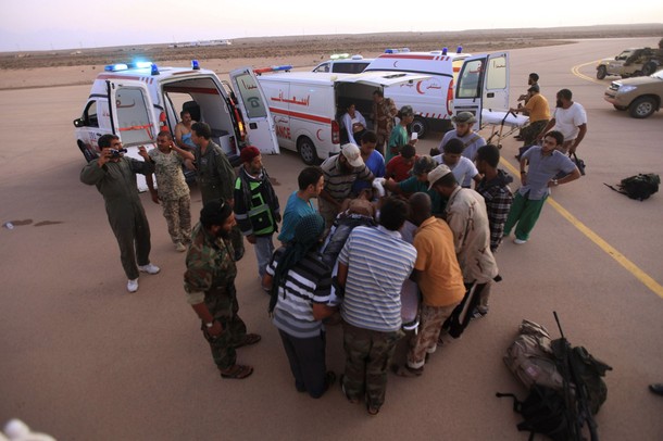 Several anti-Gaddafi fighters who were injured amid heavy shelling in Sirte wait before being transported in Red Crescent helicopters from Ras Lanuf to Benghazi