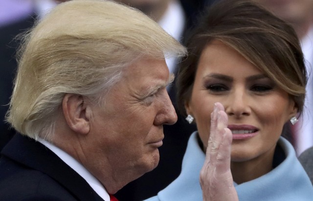Donald Trump raises his hand as he is sworn in as the 45th president of the United States as his wife Melania looks on during ceremonies on the West front of the U.S. Capitol in Washington