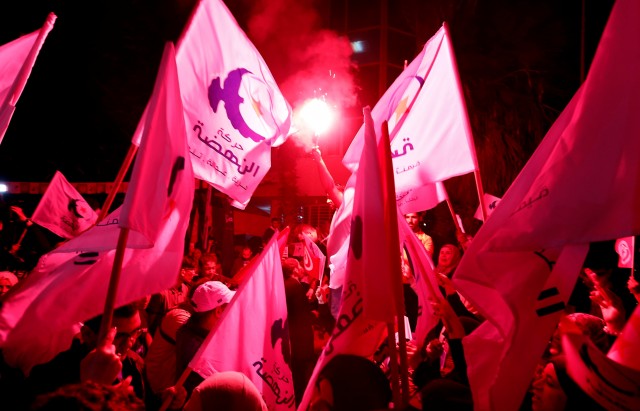 Supporters of the Islamist Ennahda party celebrate outside the party's headquarters after claiming victory in a local poll in Tunis, Tunisia