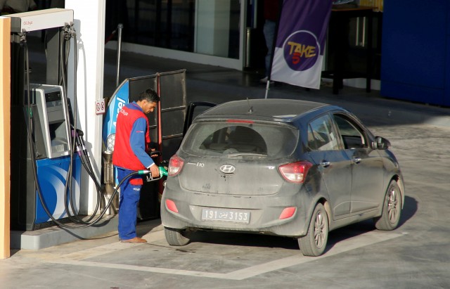 FILE PHOTO: A station attendant pumps fuel into a customer's car in Tunis, Tunisia