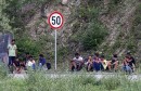Migrants sit on the street next to the border between Bosnia and Herzegovina and Croatia in Velika Kladusa, picture taken from Maljevac