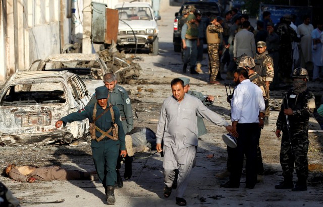 Afghan security forces carry the body of a victim after an attack in Jalalabad, Afghanistan