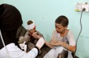 A doctor treats children injured by an airstrike in Saada