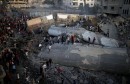 Palestinians gather around a building after it was bombed by an Israeli aircraft, in Gaza City