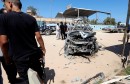 Security personnel is seen next to the remnants of a vehicle at the scene of a gun attack at Kaam checkpoint in Zliten east of Tripoli