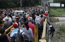 FILE PHOTO: A man gets off the bridge as people queue to try to cross the Venezuela-Colombia border through Simon Bolivar international bridge in San Antonio del Tachira