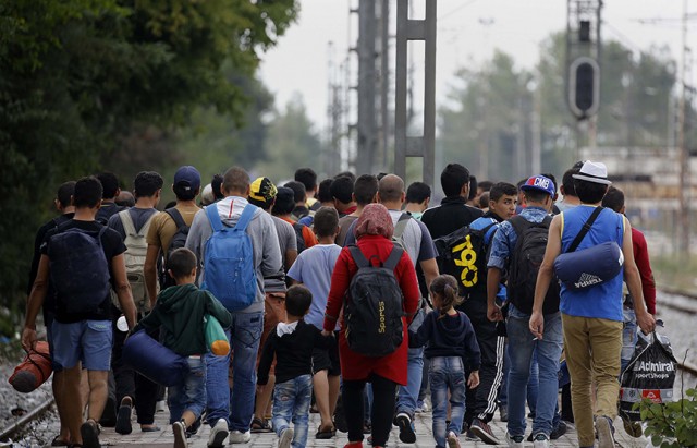 Syrian refugees walk towards Greece's border with Macedonia