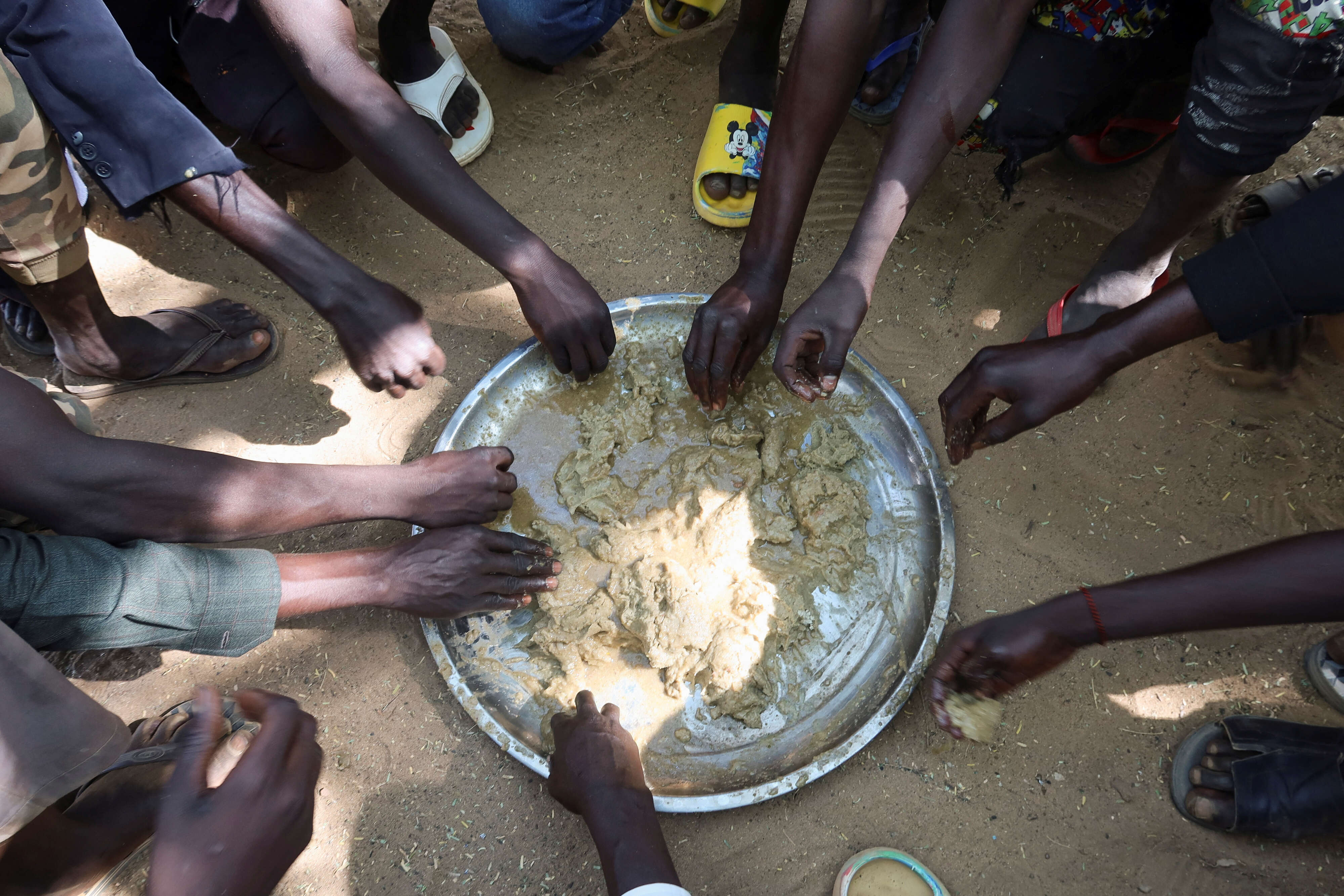 Refugees eat food in the Adre Sudanese refugee camp in Adre