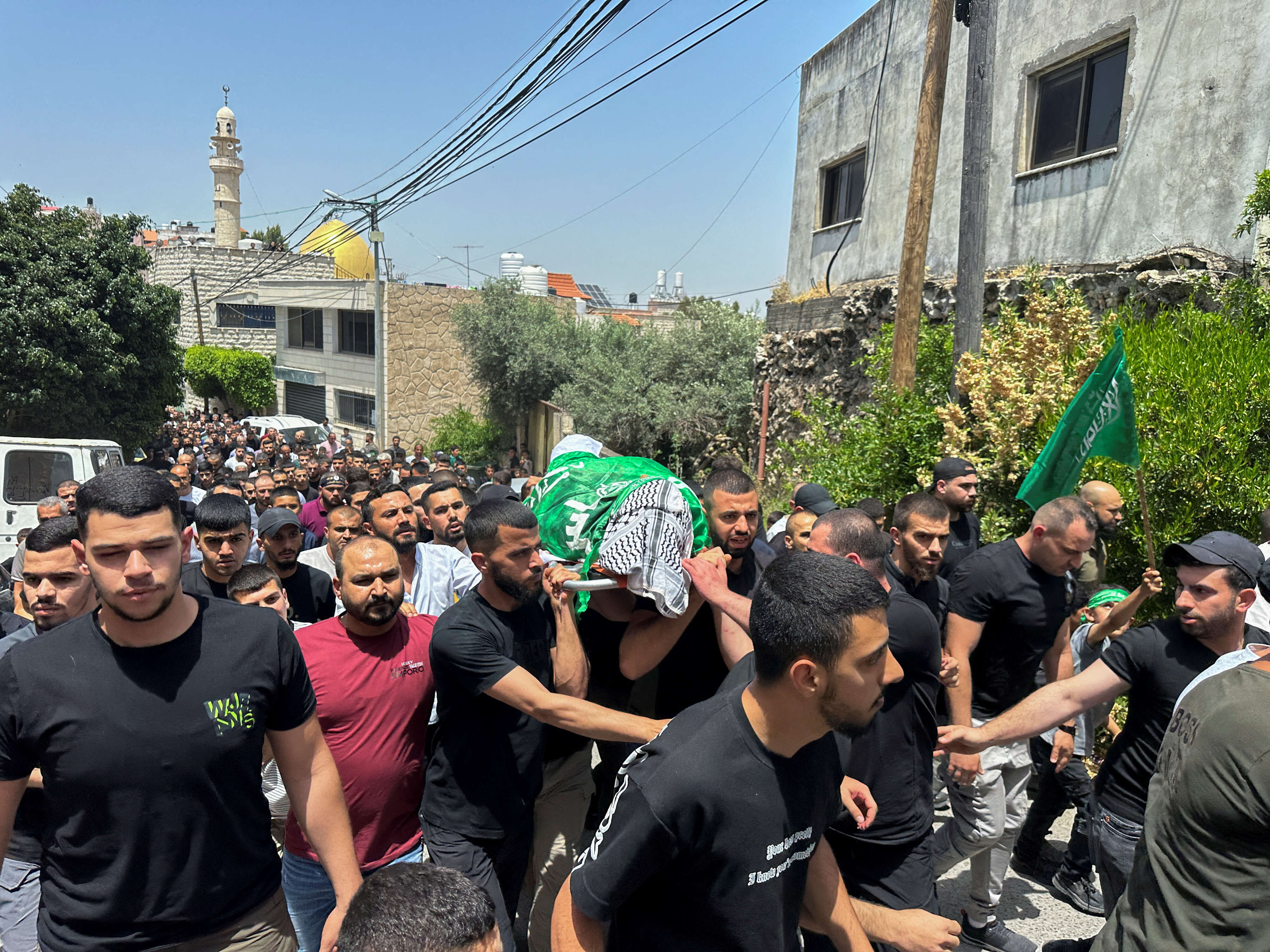 Mourners carry the body of a Palestinian teacher who was killed in an Israeli raid, during his funeral near Jenin